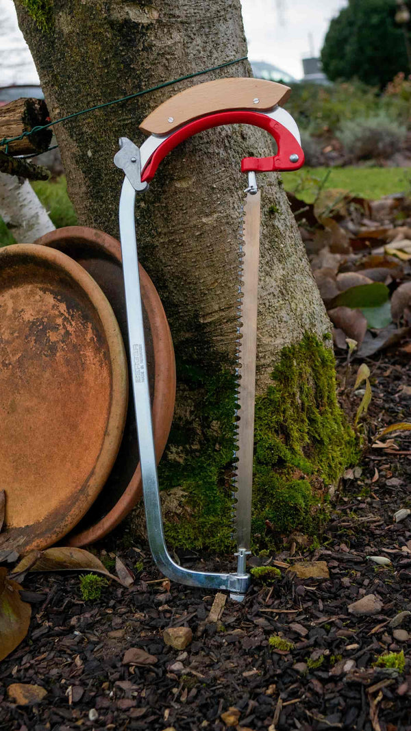 Berger Handbügelsäge lehnt an einem Baum